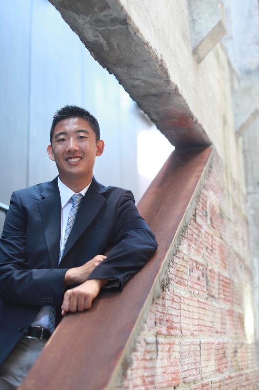 A profile photo of Alan Yu standing on a brick staircase