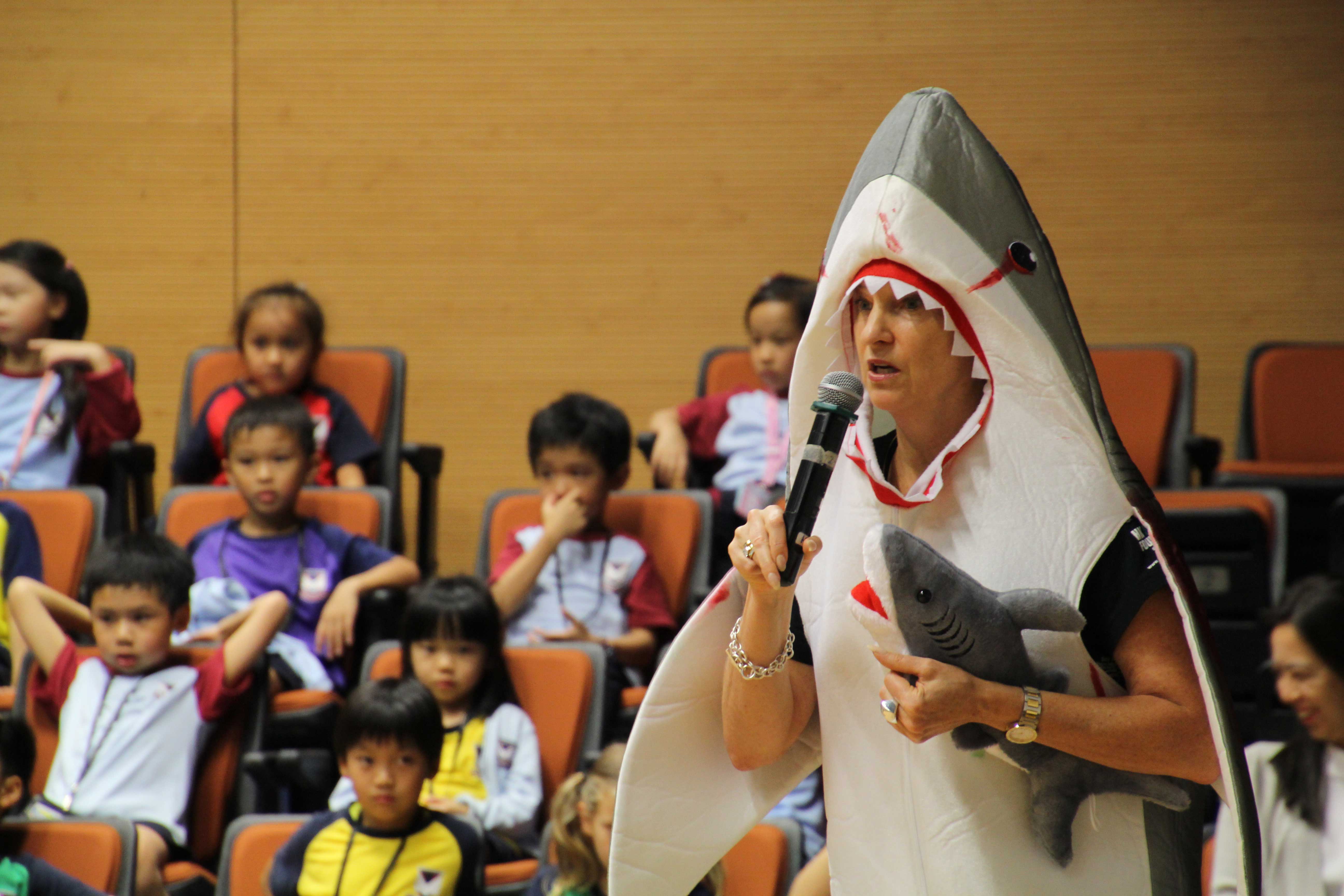 Women Dressed up in Shark Outfit Giving a Talk