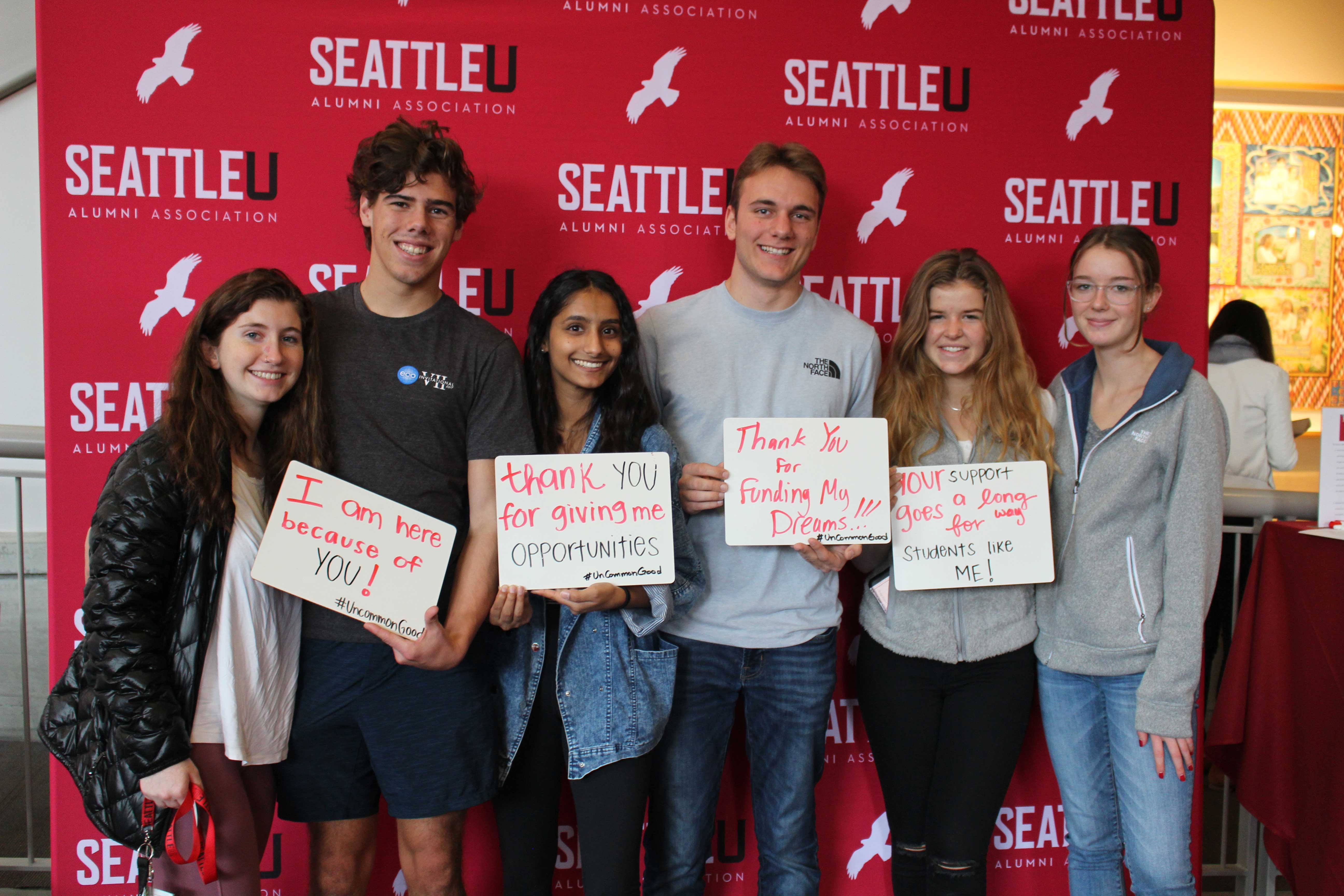 Thankful students holding signs at a photobooth