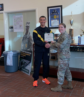 Man in Army workout shaking hands with LTC Maier in greens