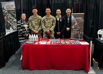 Five Cadets at recruitment table smiling