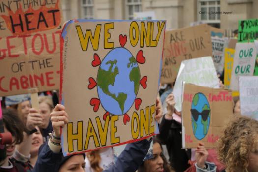 A climate activist holding a sign saying that we only have one earth