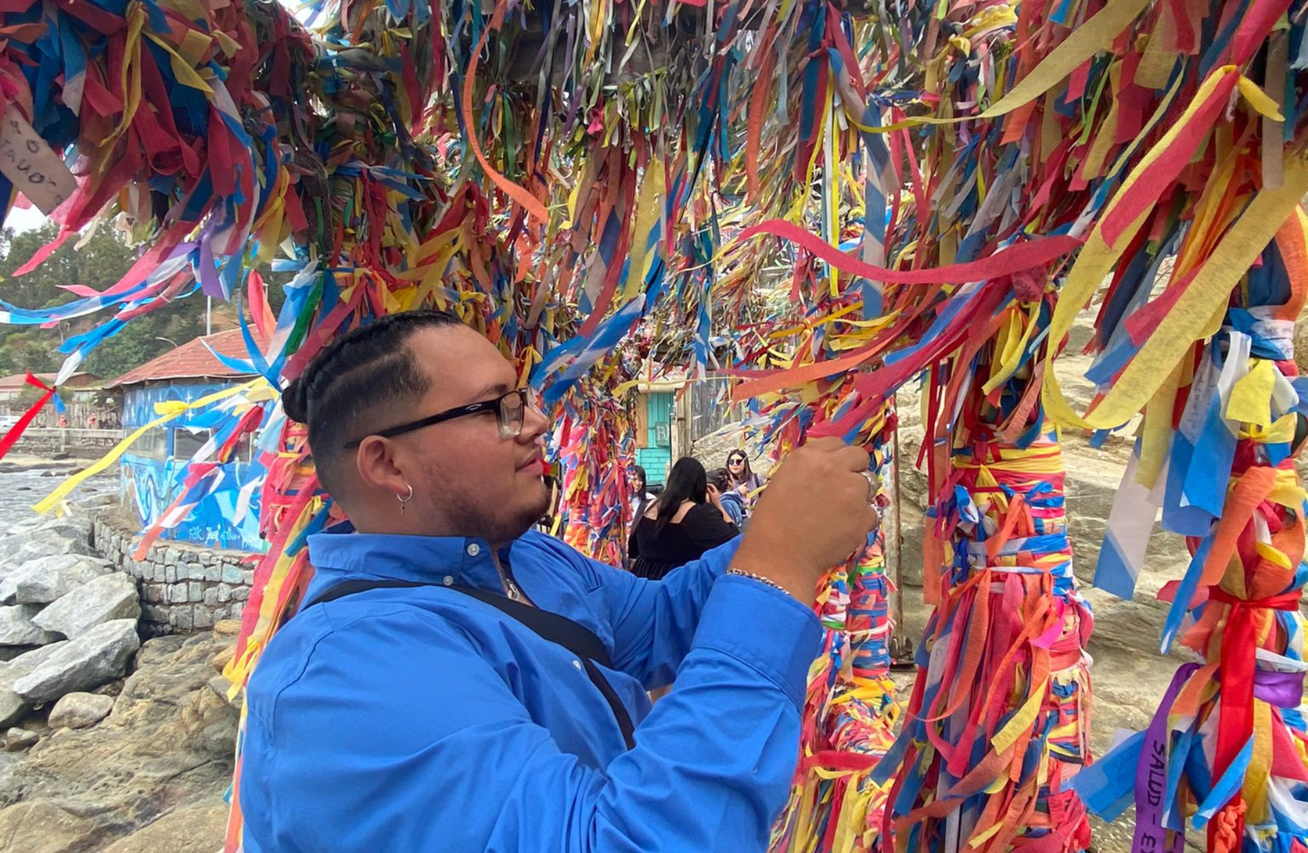 Man tying a ribbon amongst a sea of ribbons on a structure