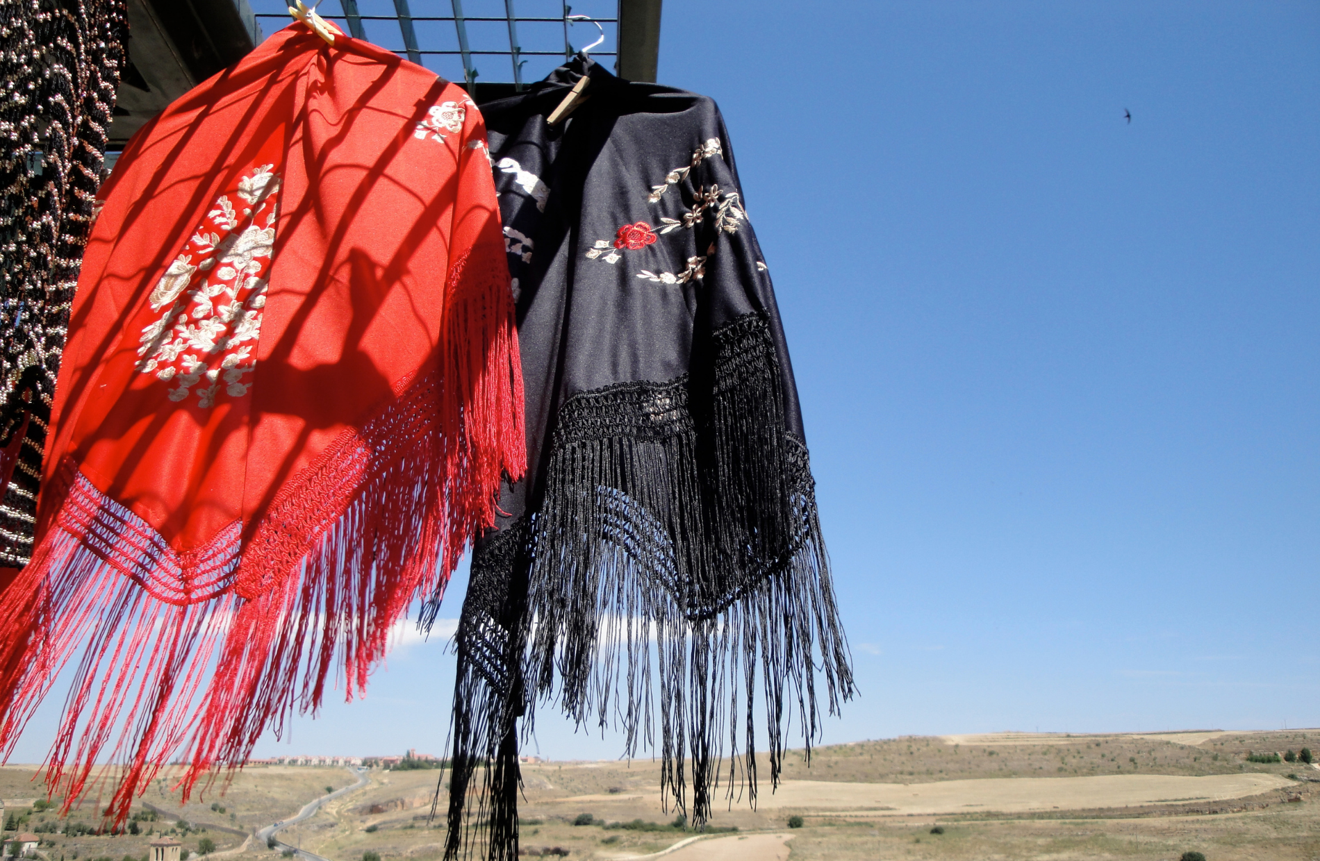 hanging Spanish shawls in the foreground of Spanish countryside