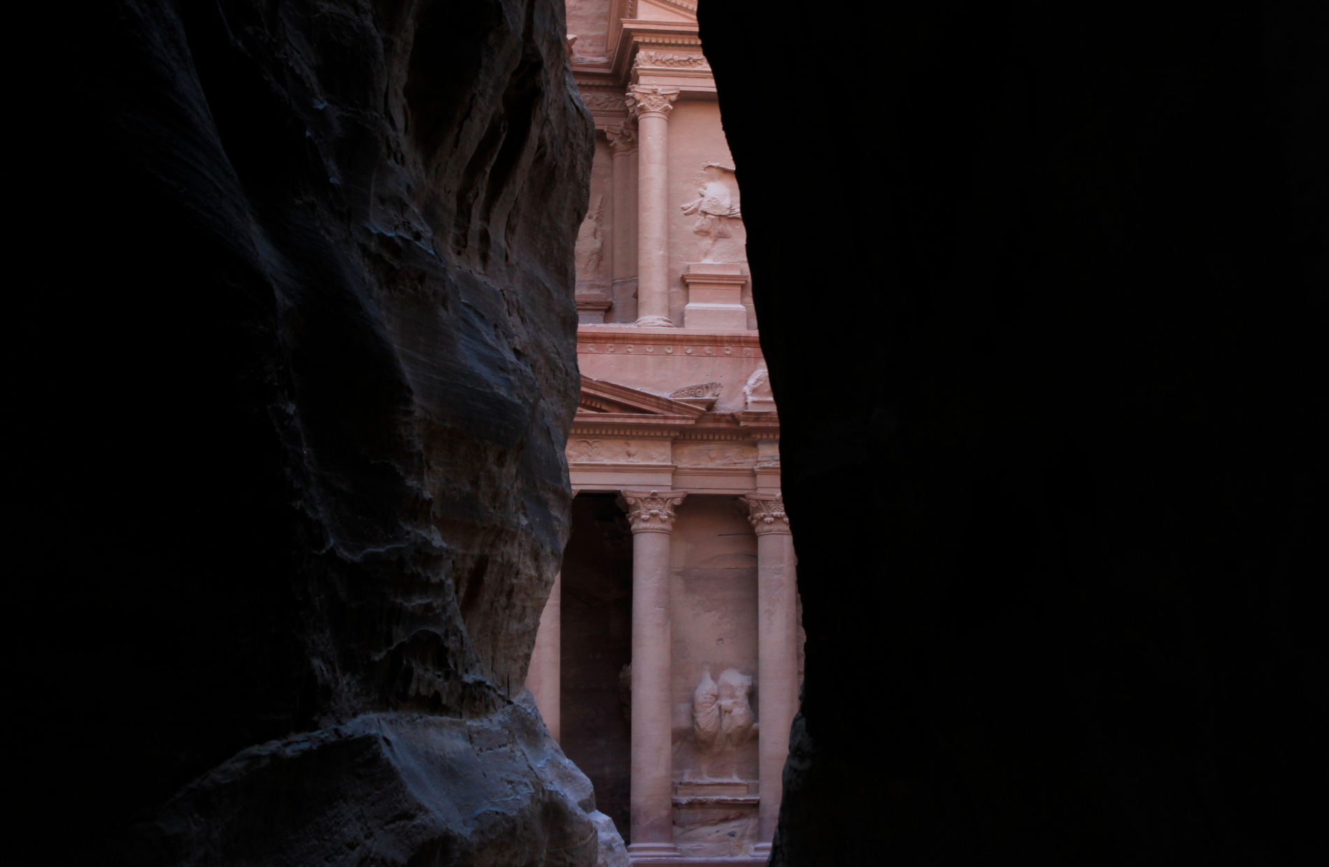 building of Petra peeking between two rock faces