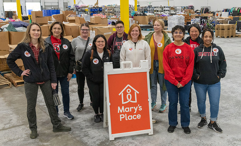 A group of volunteers around a Mary's Place sign