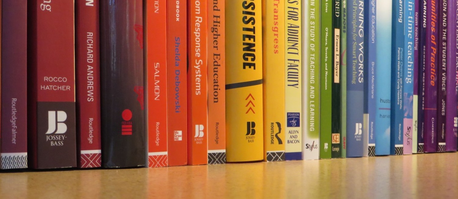 Books from the Center's library with spine colors spanning the rainbow