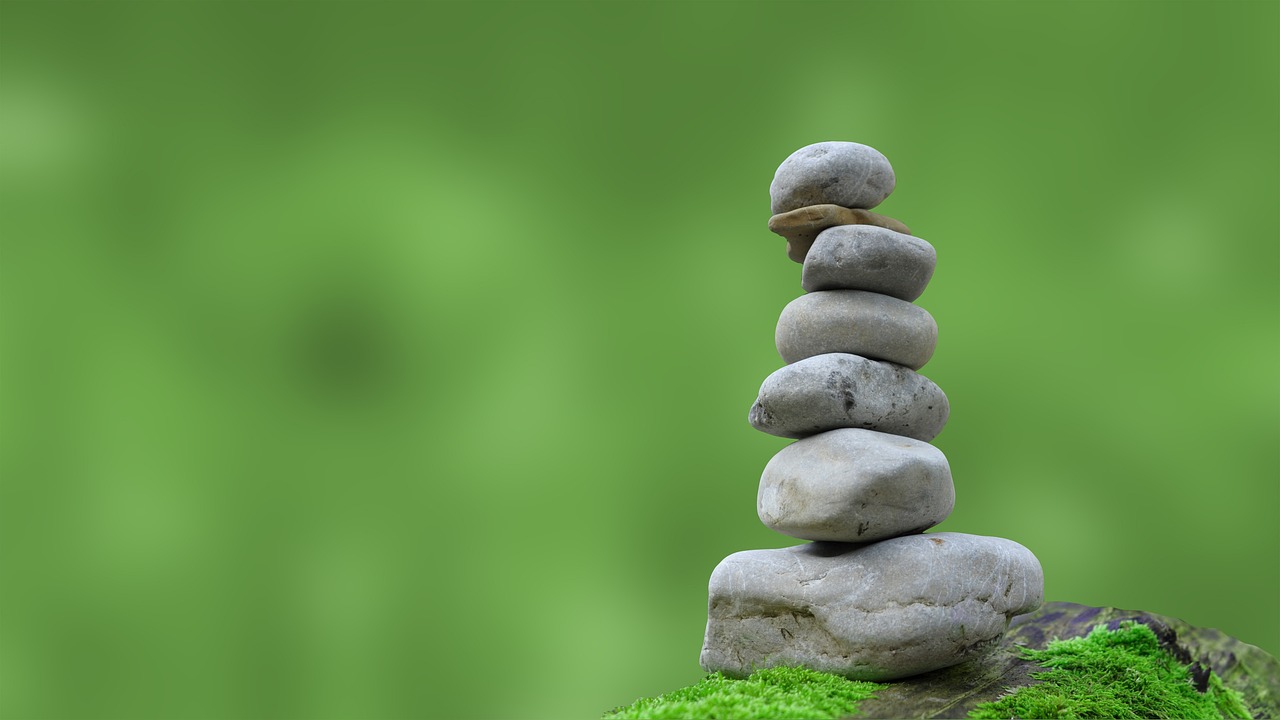 Stack of grey stones against a lush green background