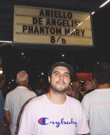 Photo of Anellio de Angelis in front of movie marquee