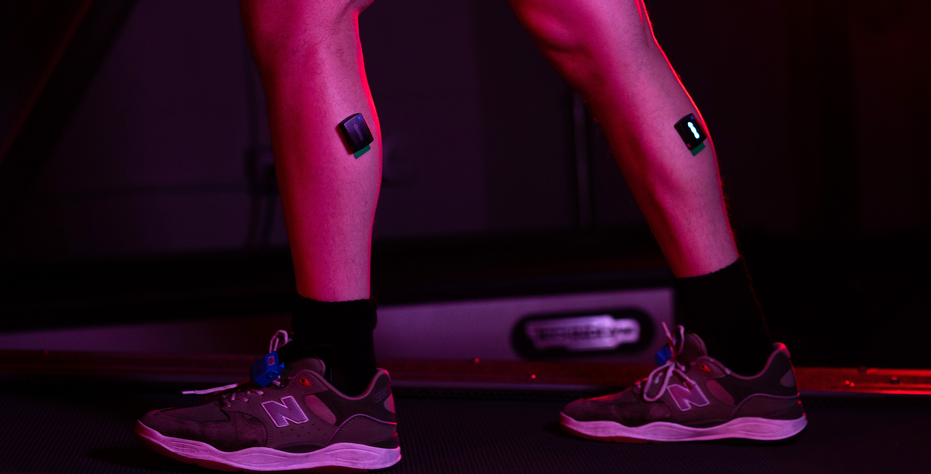 Person's legs with monitors attached while walking on treadmill