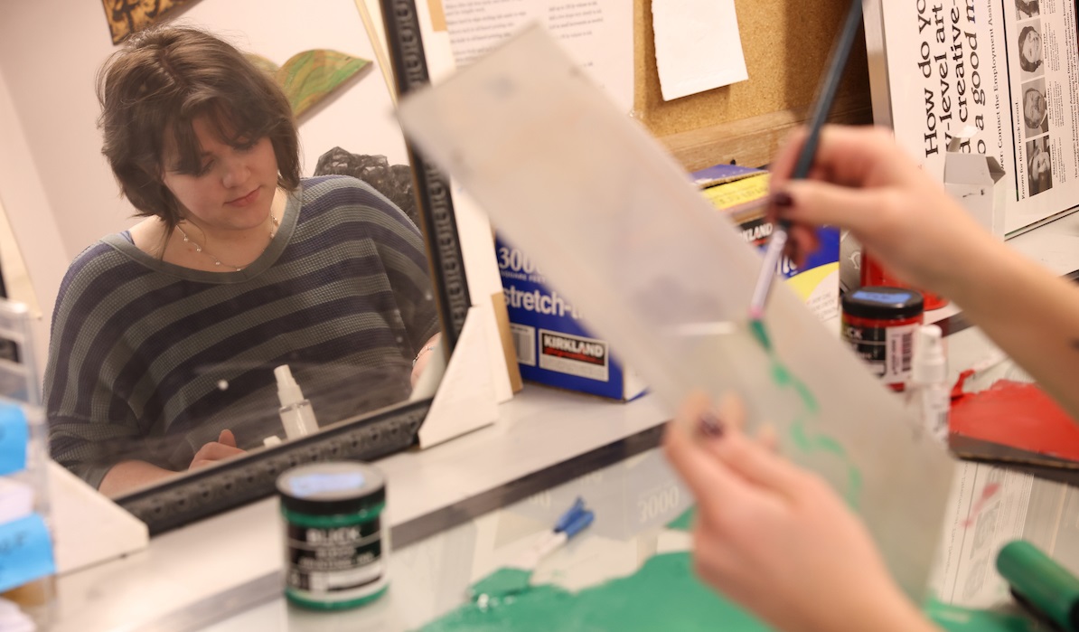 Student painting reflected in mirror