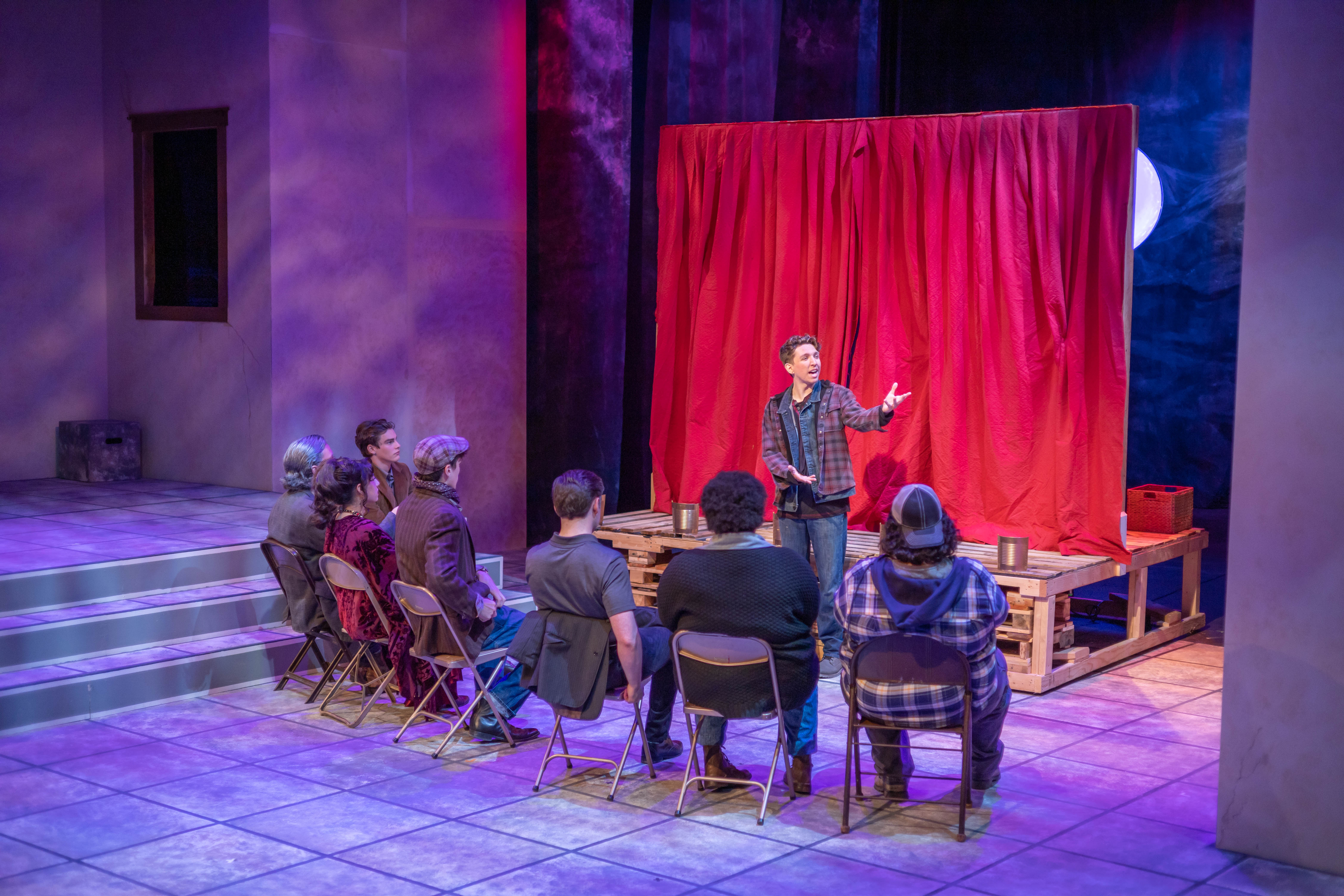 Group of people sitting in front of an orator mid-speech