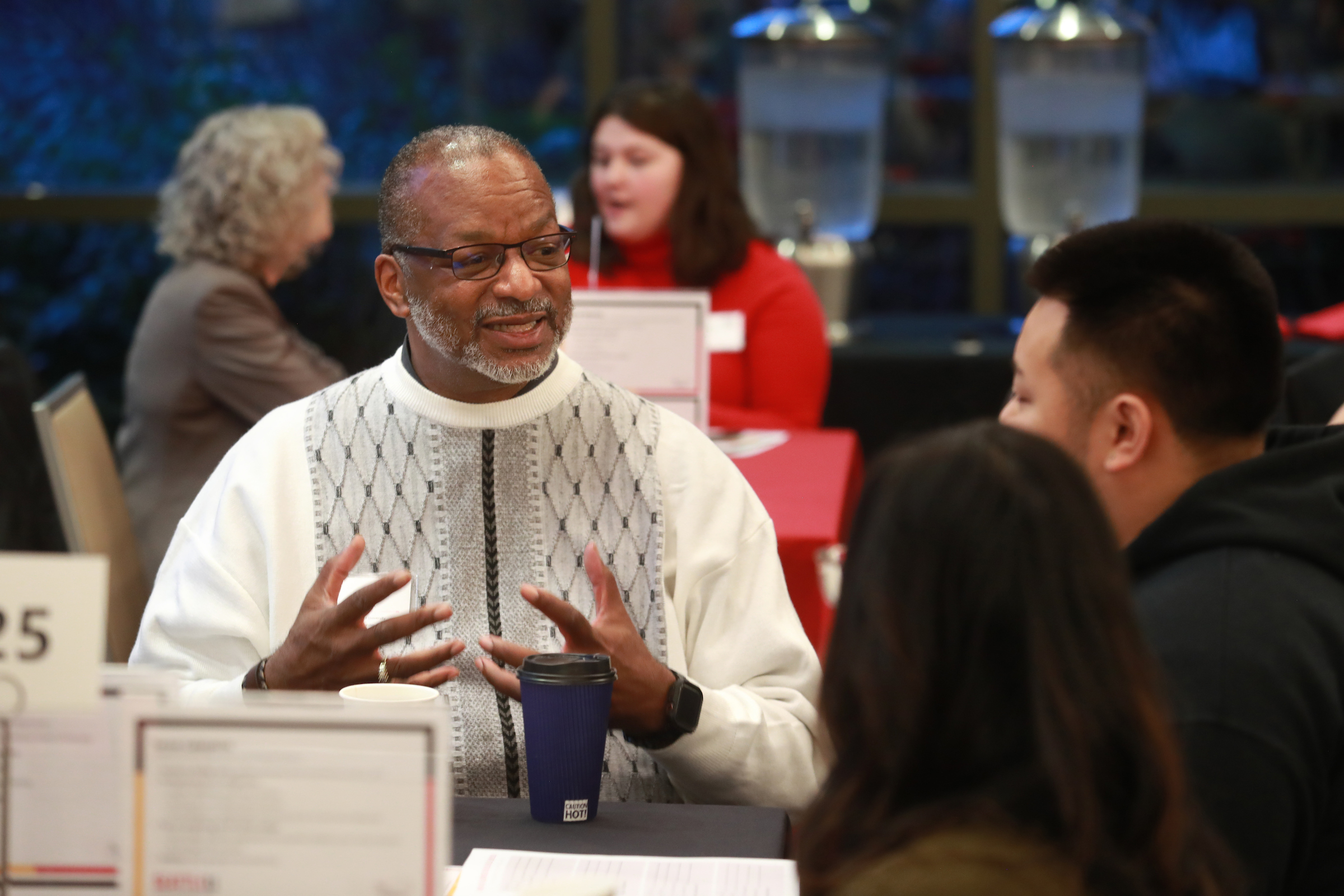 An alum mentoring students at a networking event on campus