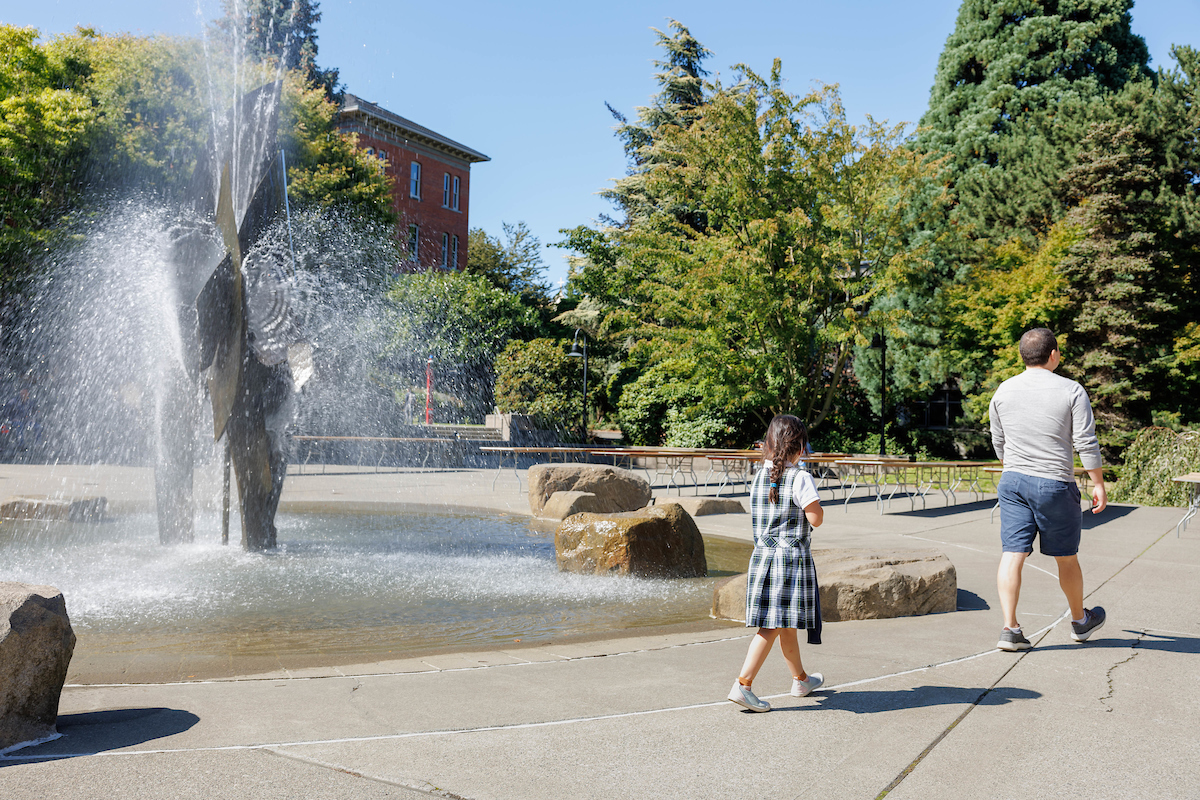 a family walks through the Quad on a summer day