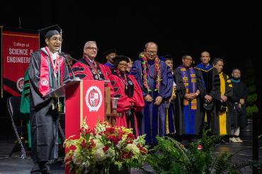 Sahil Bathija on stage at commencement with others